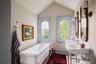 Full bathroom featuring a freestanding bath, tile patterned flooring, and lofted ceiling