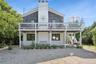 Two-story residence featuring a shingled upper level and white brick lower level