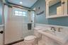 Bathroom featuring tile patterned floors, toilet, sink, and walk in shower