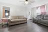 Spacious room featuring wood-finish flooring, white walls, and a ceiling fan