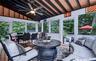 Screened porch featuring a vaulted ceiling with exposed beams, wood-finish flooring, and a ceiling fan