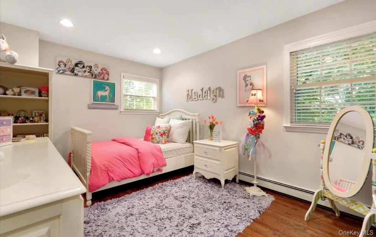 Bedroom featuring wood finished floors, a baseboard heating unit, and recessed lighting
