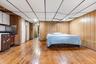 Bedroom featuring light wood-type flooring, a paneled ceiling, and wooden walls