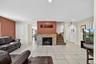 Living room with light tile patterned flooring, recessed lighting, a fireplace, and arched walkways