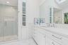 Full bath featuring a skylight, vanity, a stall shower, marble look tile flooring, and recessed lighting