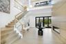 Stairs featuring a high ceiling, a glass covered fireplace, recessed lighting, and wood finished floors