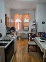 Kitchen featuring range, hardwood / wood-style flooring, brown cabinetry, an ornate ceiling, and radiator