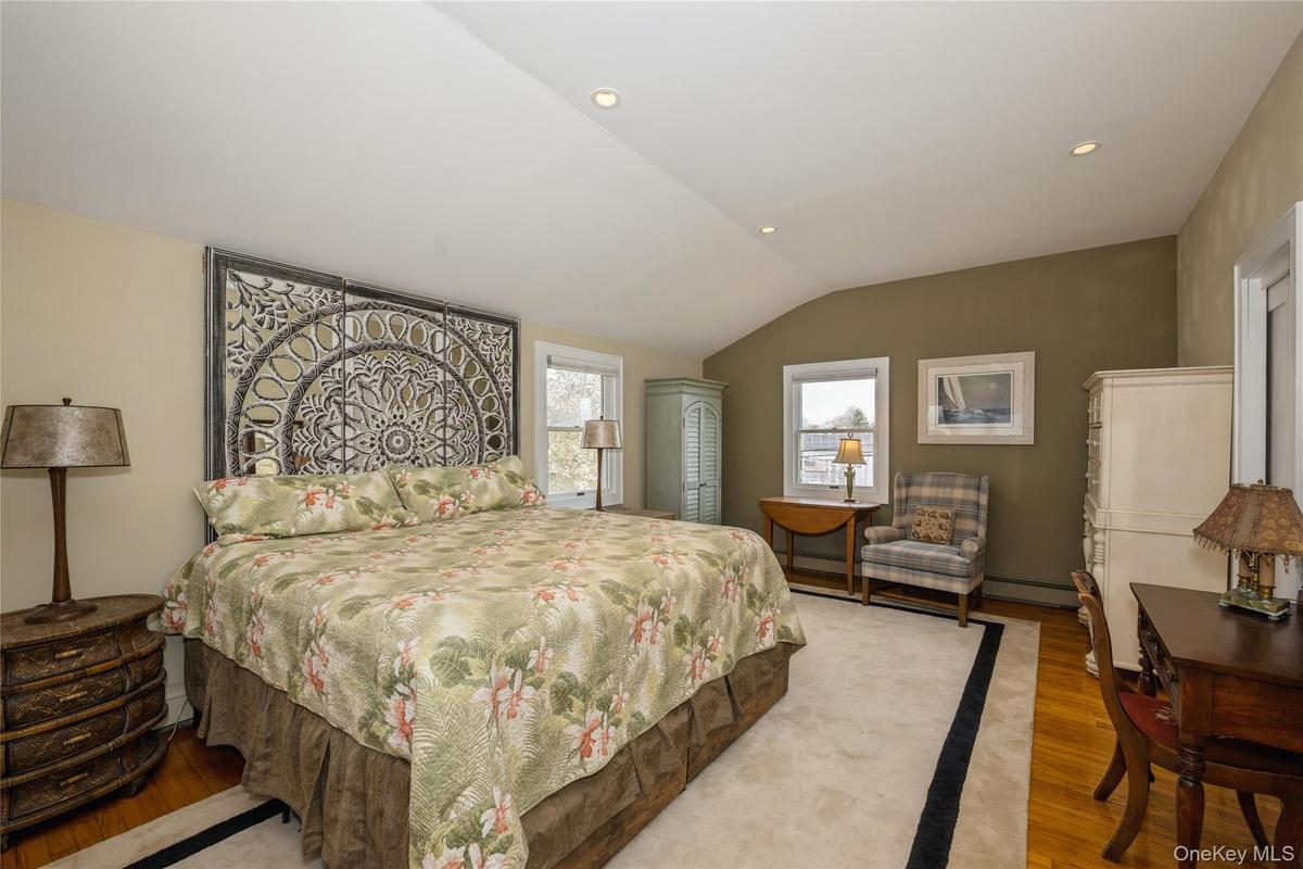 Bedroom featuring lofted ceiling, recessed lighting, wood finished floors, and baseboard heating
