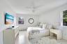 Bedroom featuring light wood-style flooring, a ceiling fan, and baseboard heating