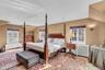 Angled ceilings, warm wall tones, two casement windows with privacy blinds, and a built-in wall sconce