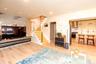 Open-concept living area featuring light wood-finish flooring, recessed lighting, and a modern staircase with cable railing