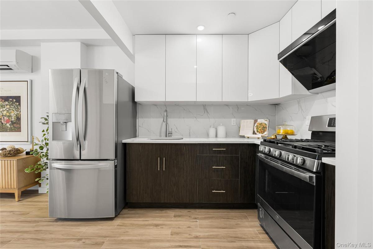 Kitchen with light countertops, a sink, stainless steel appliances, and extractor fan