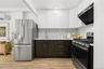Kitchen with light countertops, a sink, stainless steel appliances, and extractor fan