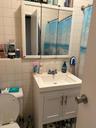 Full bath with tile walls, vanity, backsplash, and a shower with curtain