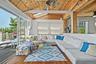 Living area featuring wood-finish flooring and a wood-paneled ceiling with exposed beams