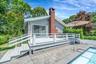 Back of house with a deck, a chimney, and a patio area