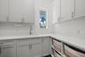 The laundry room has custom cabinetry and quartz counter tops.