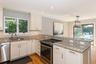 Kitchen featuring a peninsula, appliances with stainless steel finishes, light wood finished floors, light stone counters, and recessed lighting