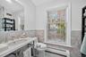 Bathroom featuring tile walls, a baseboard heating unit, wainscoting, and vanity