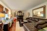 Living room featuring dark wood-style floors, ornamental molding, and a baseboard heating unit
