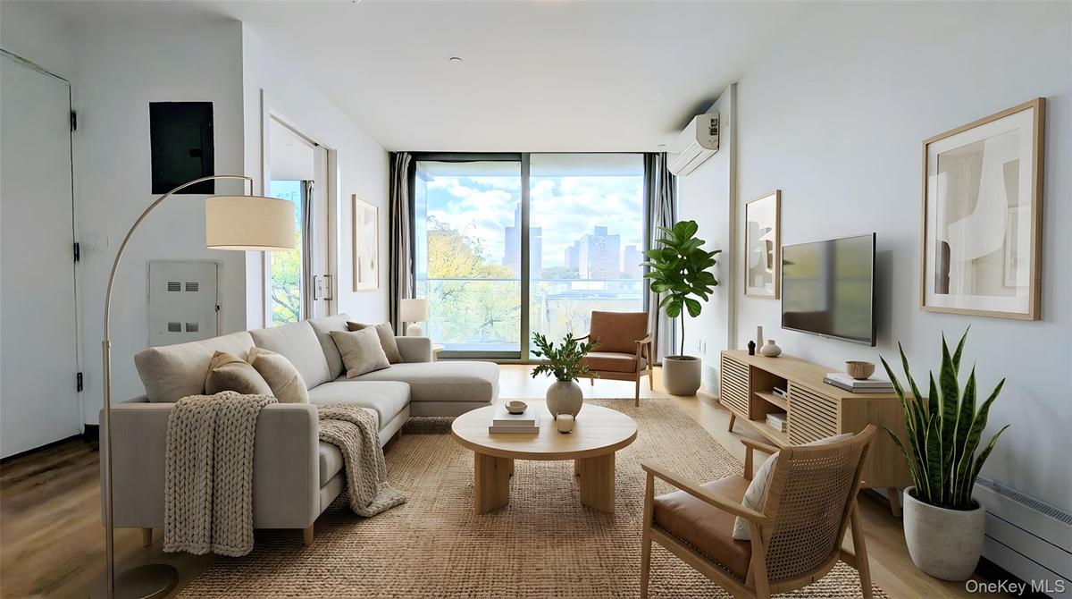 Living room with a wall of windows, wood finished floors, and a wall mounted AC