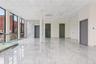Empty room featuring marble tiled flooring, a drop ceiling, and expansive windows