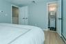 Bedroom featuring connected bathroom, light hardwood / wood-style floors, baseboard heating, and sink
