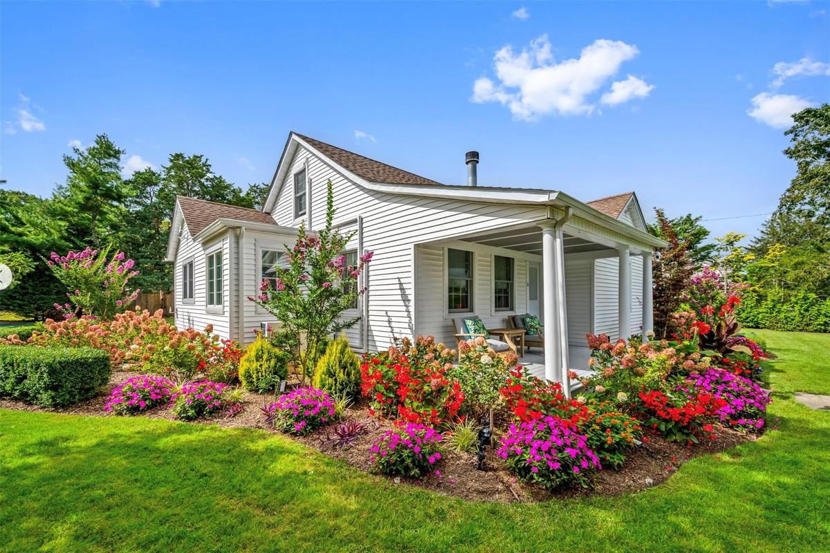 View of side of home with a porch and a yard