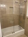 Another view of the Hall Bath with beautifully tiled walls and bathtub.