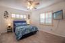 Master with queen bed, tv, side tables with lamp, ceiling fan, window to the outside.