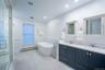 Bathroom featuring a baseboard heating unit, wainscoting, a sink, and visible vents