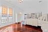 Rich wood-finish flooring complements crisp white walls and crown molding