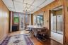 Dining area with radiator heating unit, a chandelier, wood walls, healthy amount of natural light, and light wood-style floors