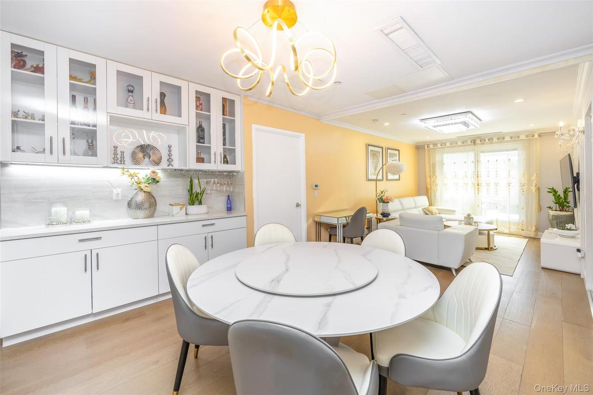 Dining area featuring light wood-style floors, a chandelier, crown molding, and recessed lighting