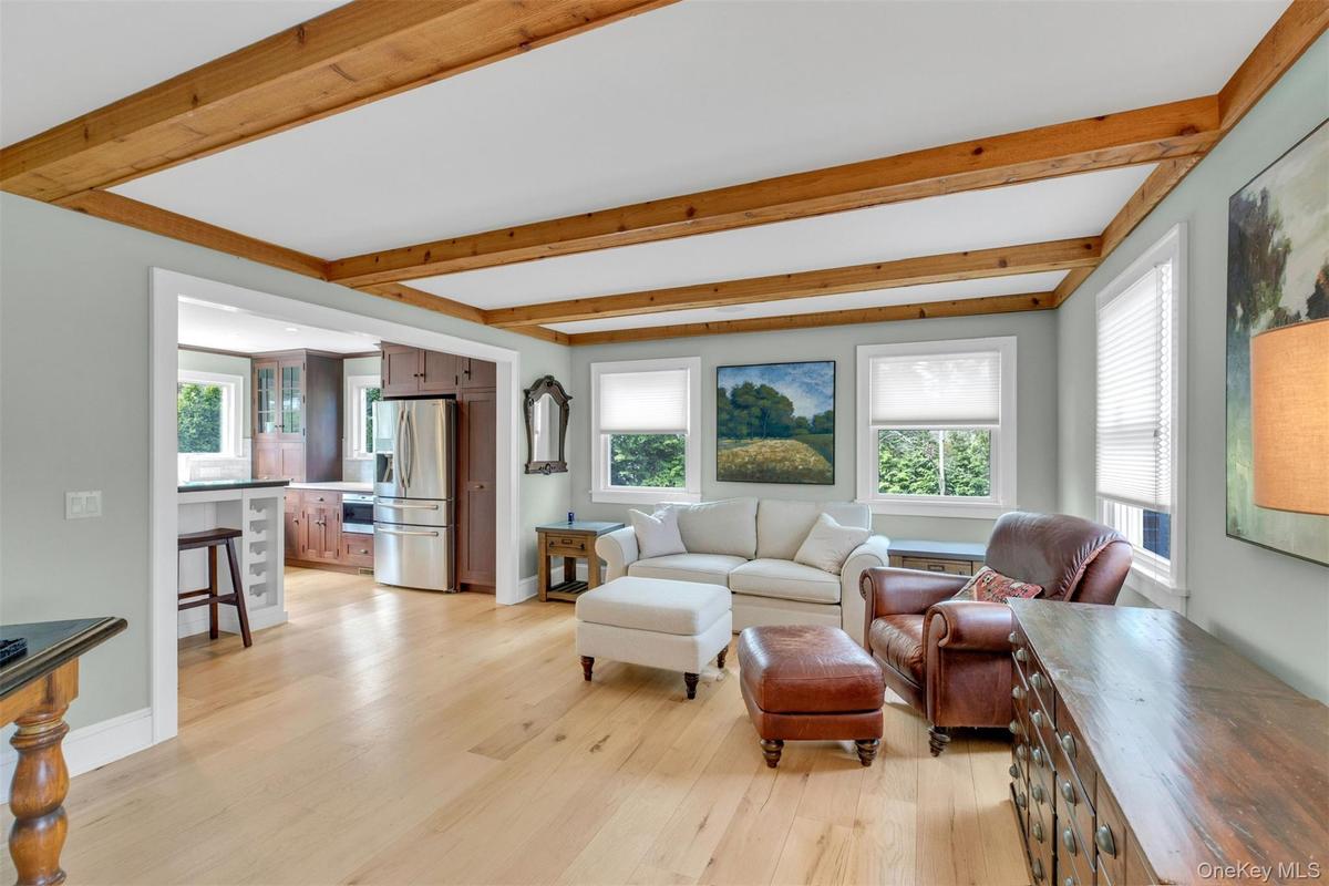 Living area featuring beam ceiling and light wood-style flooring