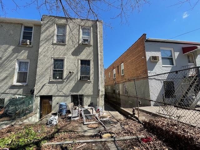 Back of property featuring stucco siding, fence, and cooling unit