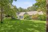View of front of property featuring fence and a front lawn