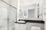 Bathroom featuring bath / shower combo with glass door, radiator heating unit, vanity, crown molding, and a towel warming rack
