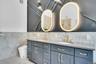 Double vanity with custom mittors and designer wainscoting.