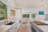The home seamlessly flows from living to kitchen to dining all surrounded by windows and doors with tropical views.