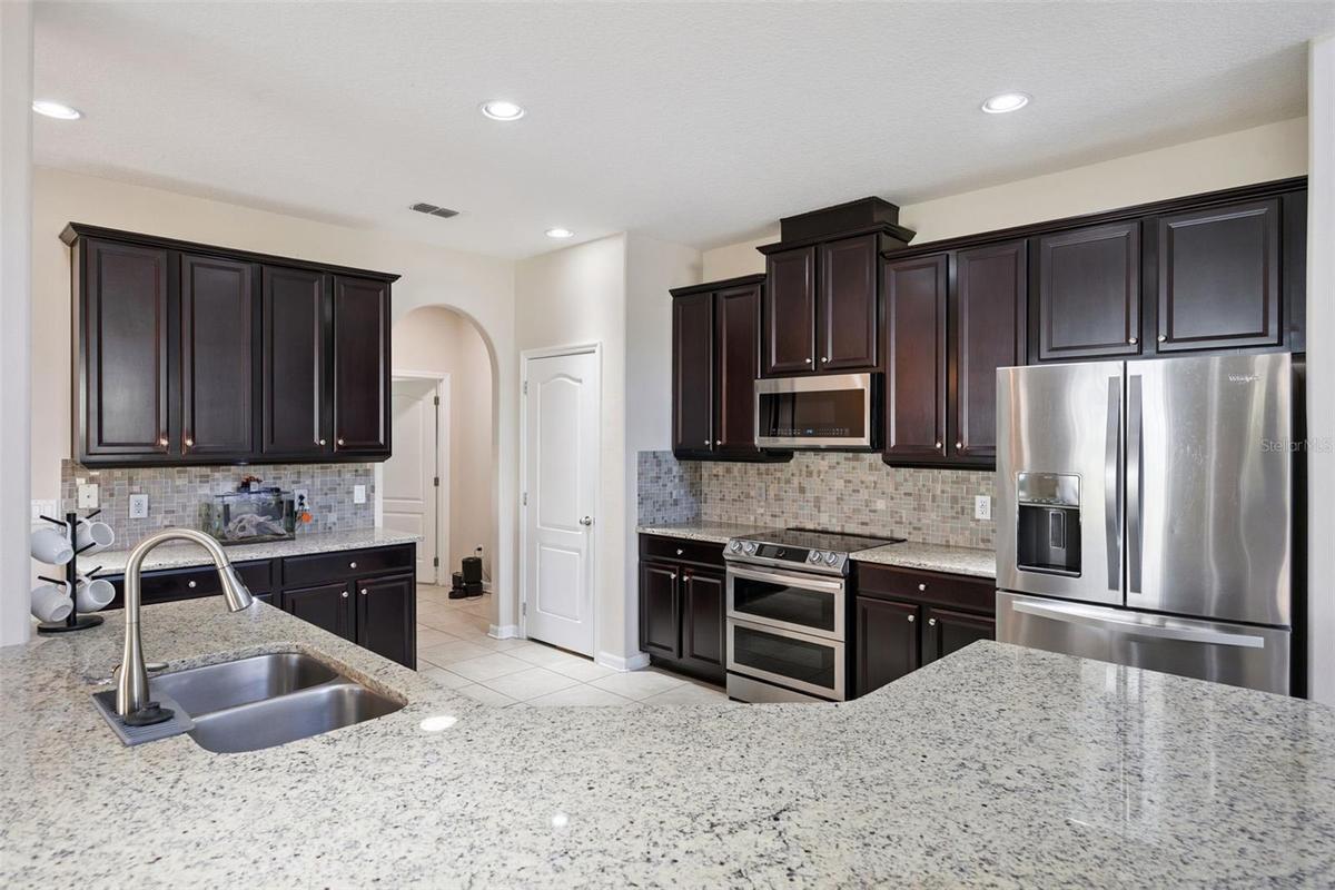 Kitchen features granite counters and timeless espresso cabinets