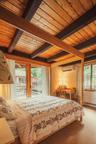 Bedroom featuring beam ceiling, carpet flooring, access to outside, wooden ceiling, and a wall mounted air conditioner