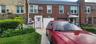 Multi unit property featuring ac unit, a garage, brick siding, and a shingled roof