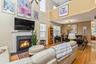 Open-concept living space featuring a fireplace, a dining area, and a lofted upper level with an overlook