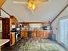 0 - Kitchen featuring light countertops, stainless steel appliances, a sink, a ceiling fan, and stone finish flooring