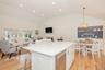 Kitchen with a kitchen breakfast bar, hanging light fixtures, a center island, lofted ceiling, and white cabinetry