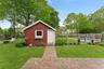 View of outbuilding featuring a fenced backyard and an outdoor fire pit