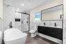 Contemporary bathroom featuring a freestanding tub with a matte black floor-mounted faucet, a double vanity with matte black fixtures, a walk-in showe