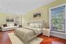 Spacious room featuring rich wood-finish flooring, recessed lighting, and crown molding