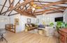 Living room featuring light wood finished floors, high vaulted ceiling, beam ceiling, and a ceiling fan